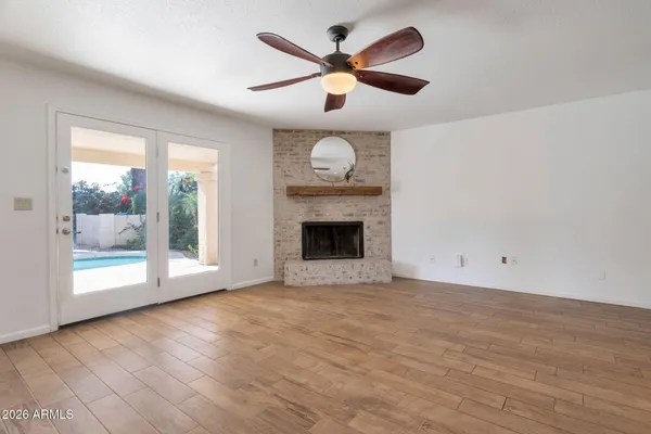 a view of an empty room with a fireplace and a window