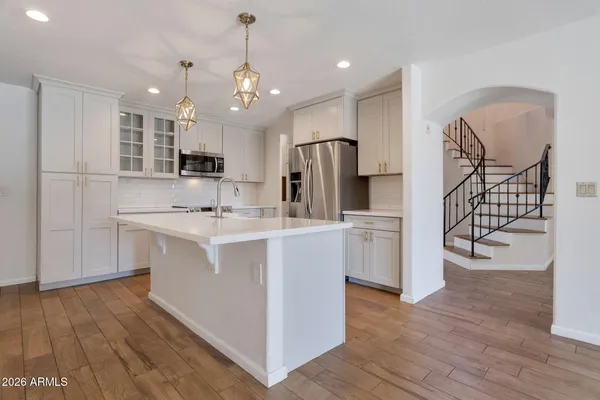 a kitchen with white cabinets and stainless steel appliances