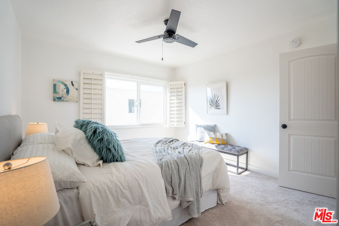 13214 Fiji Way, Unit T Marina del Rey, CA 90292 - Photo 22 of 31 a bedroom with a bed and a chandelier