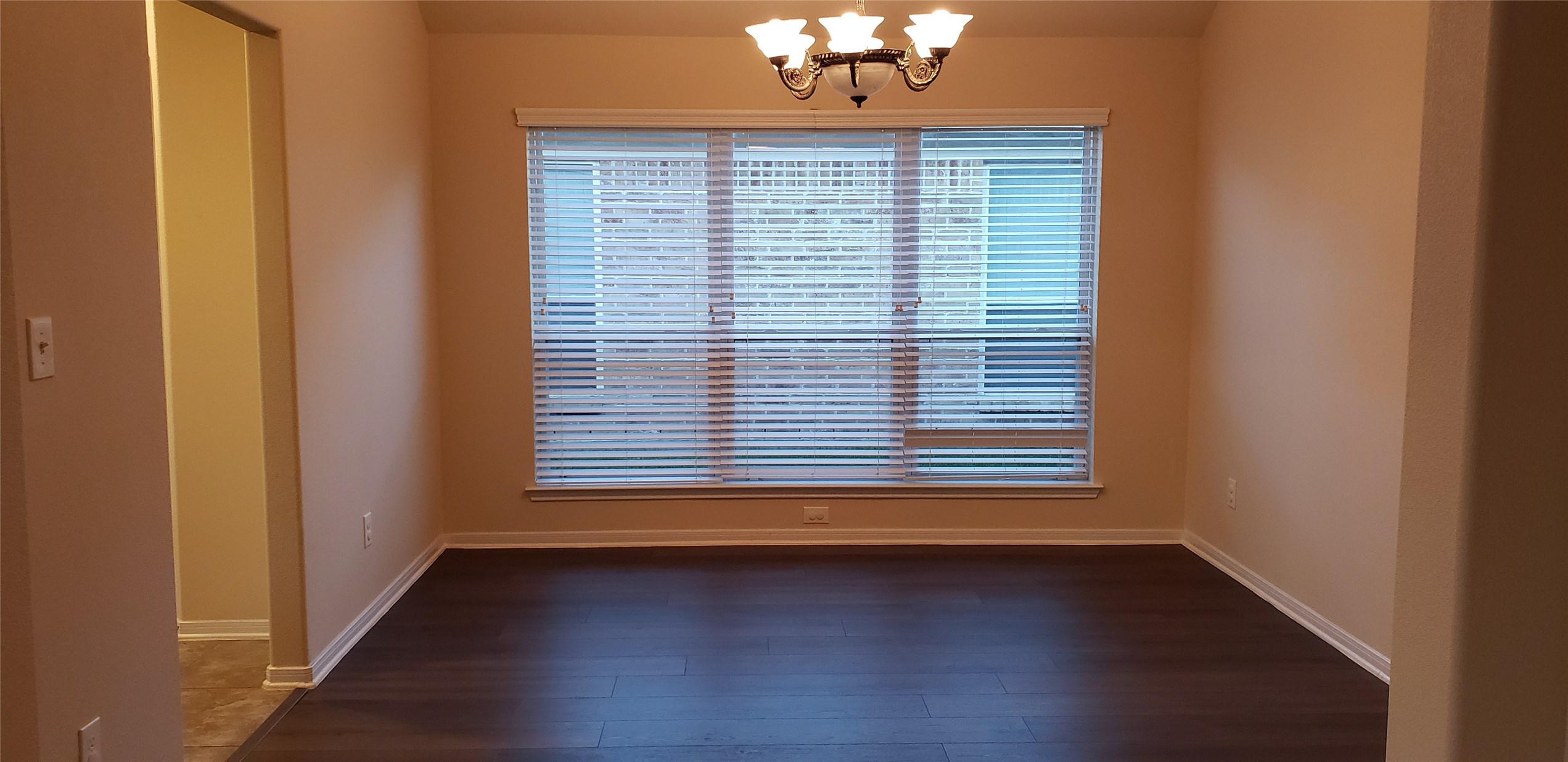 9923 Yearling Place Conroe, TX 77385 - Photo 9 of 36 an empty room with wooden floor and chandelier
