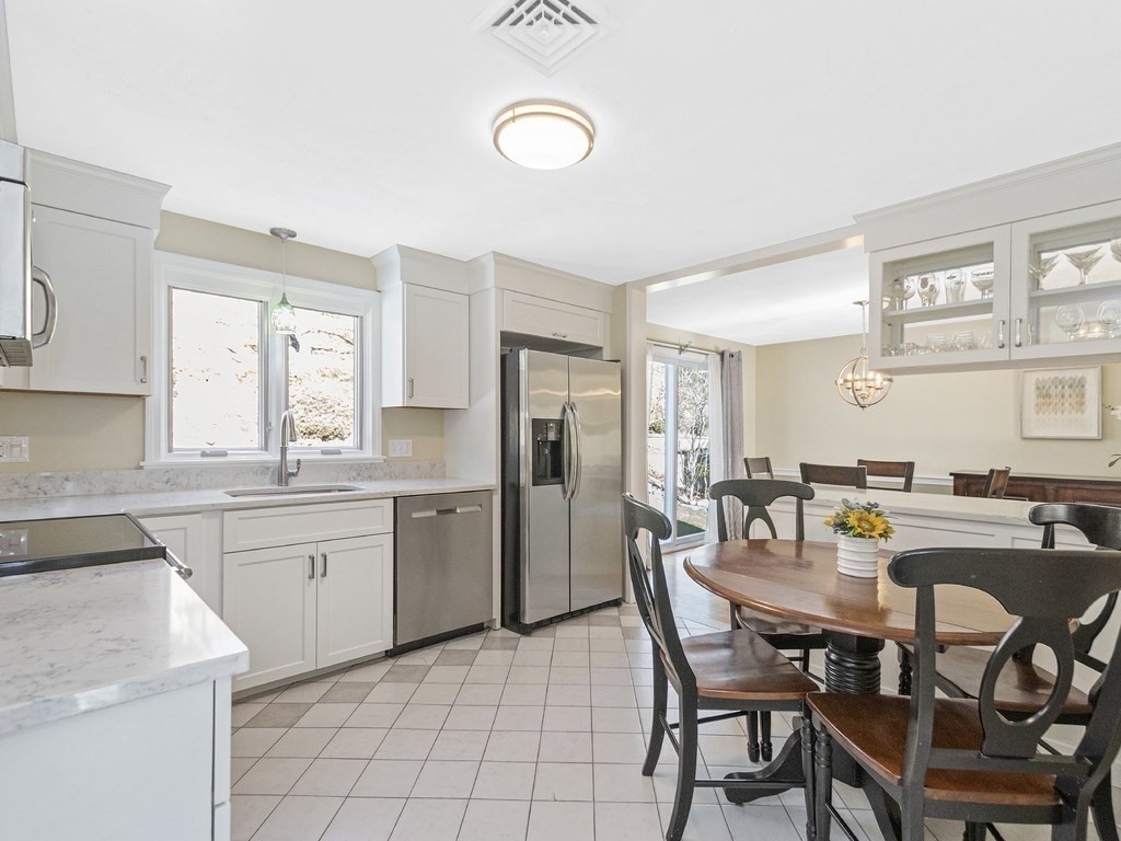 223 Hardy Pond Road Waltham, MA 02451 - Photo 4 of 38 a kitchen with a dining table chairs and refrigerator
