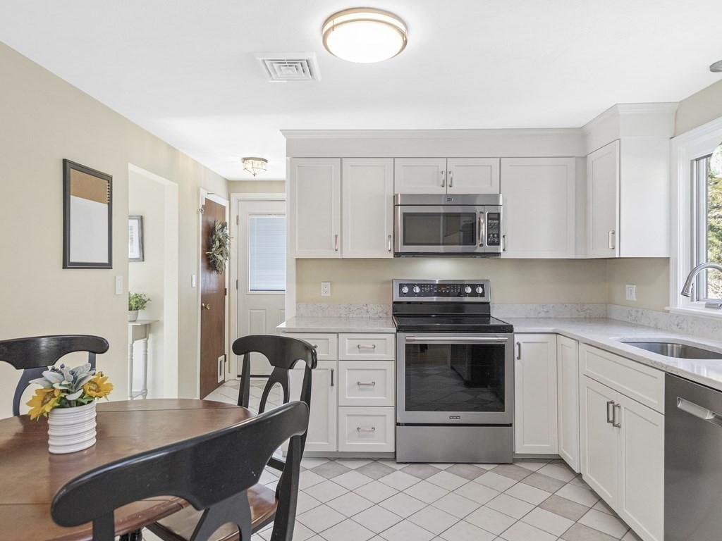 223 Hardy Pond Road Waltham, MA 02451 - Photo 5 of 38 a kitchen with stainless steel appliances granite countertop a stove top oven a sink dishwasher and cabinets with wooden floor