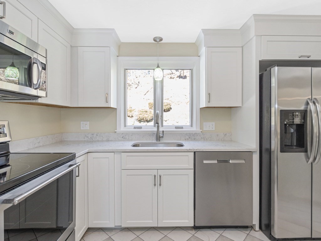 223 Hardy Pond Road Waltham, MA 02451 - Photo 6 of 38 a kitchen with white cabinets appliances and a sink