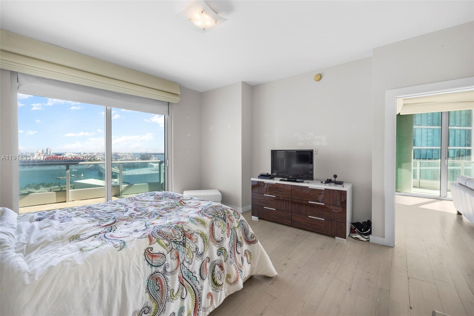 900 Biscayne Boulevard, Unit 2401 Miami, FL 33132 - Photo 16 of 33 a bedroom with a bed and a dresser