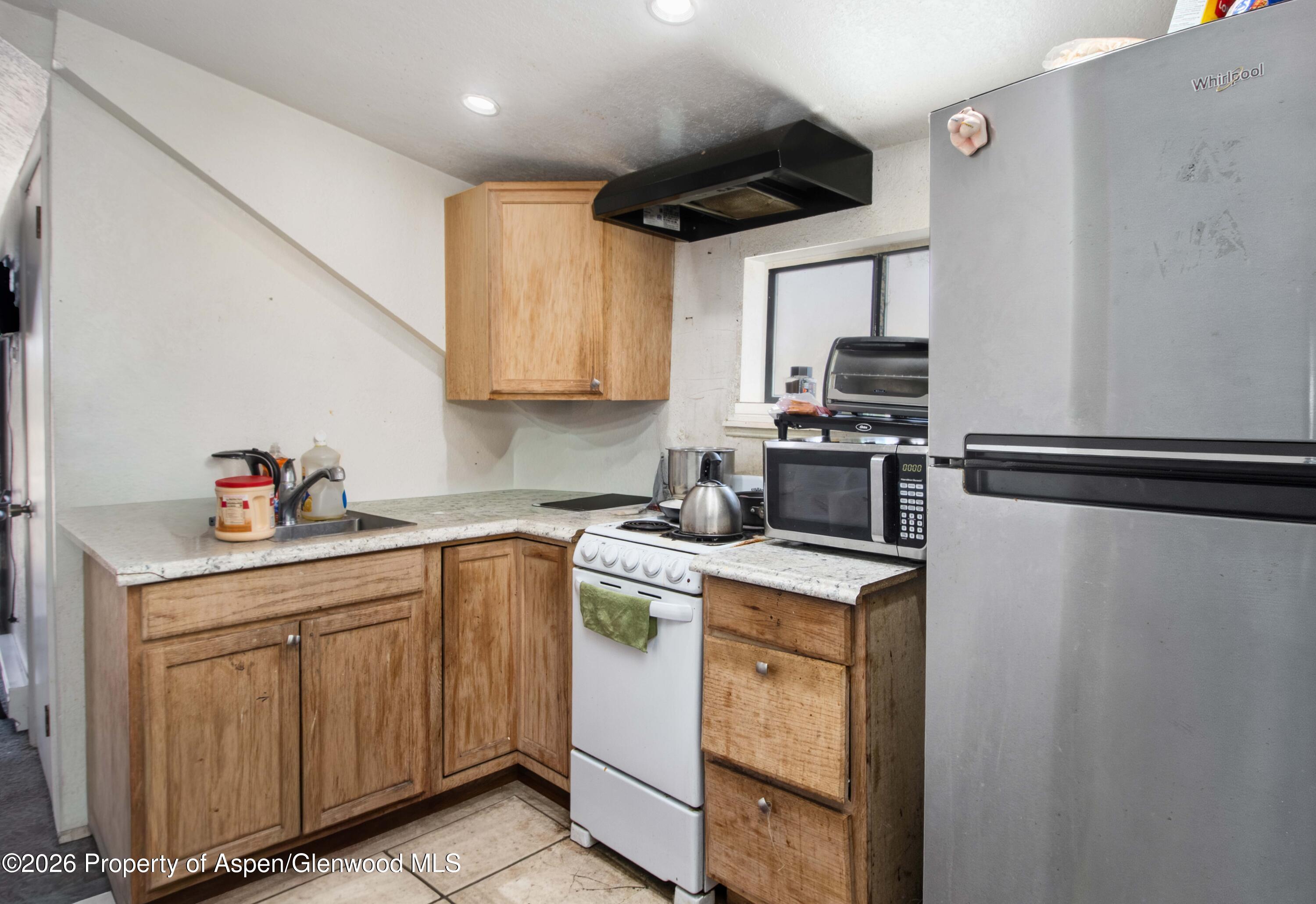 232 West 4th Street Rifle, CO 81650 - Photo 15 of 23 a kitchen with stainless steel appliances granite countertop a sink a stove and a refrigerator