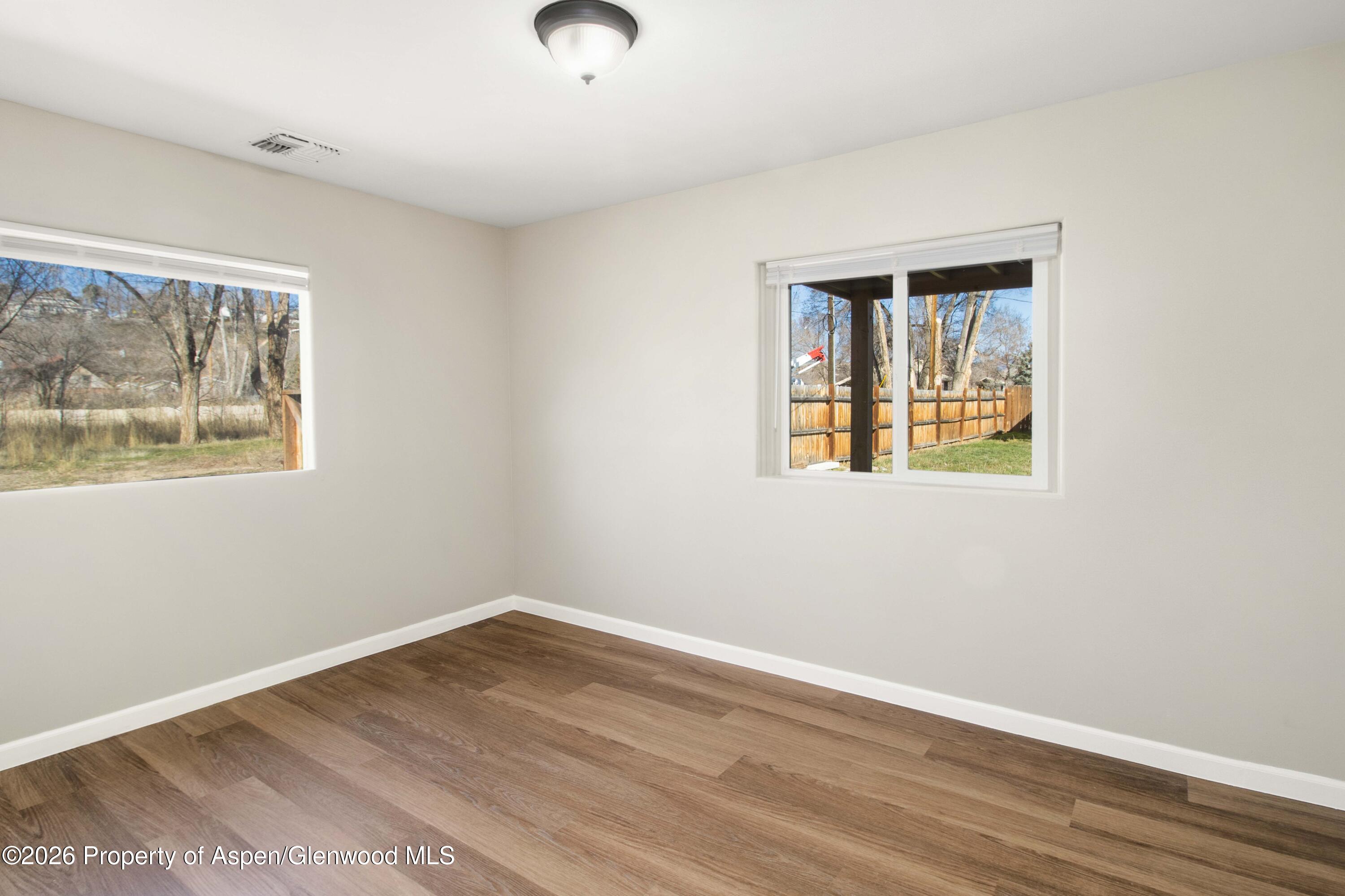 232 West 4th Street Rifle, CO 81650 - Photo 8 of 23 a view of an empty room with wooden floor and a window
