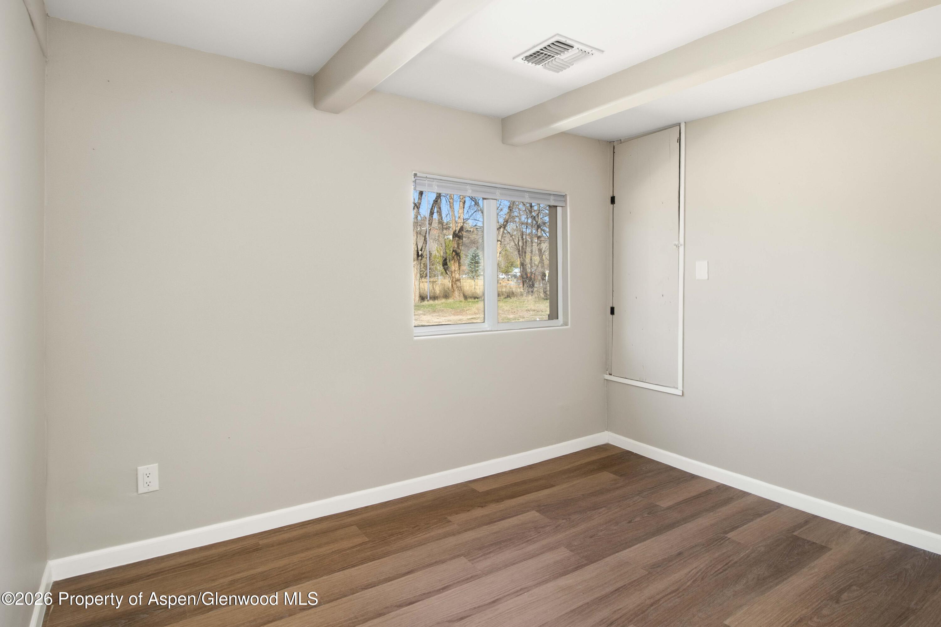 232 West 4th Street Rifle, CO 81650 - Photo 9 of 23 an empty room with wooden floor and window