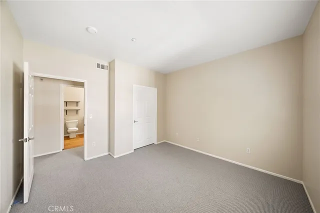 an empty room with closet and a bathroom