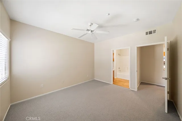 an empty room with a ceiling fan and a window