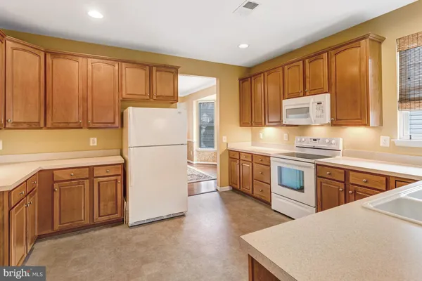 a kitchen with stainless steel appliances granite countertop a refrigerator a stove a sink dishwasher and a refrigerator