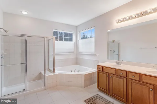 a bathroom with a tub sink and mirror