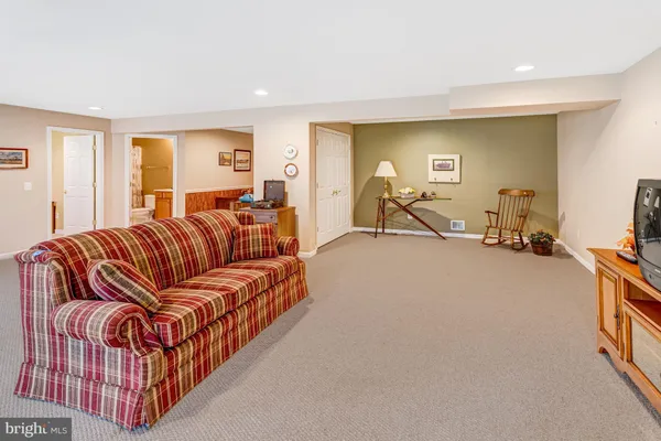 a living room with furniture a flat screen tv and a large window