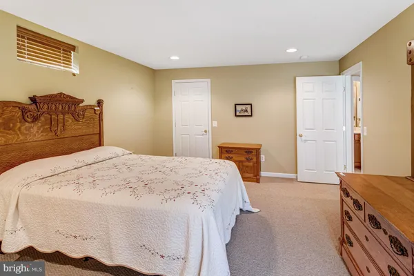 a spacious bedroom with a bed and a dresser