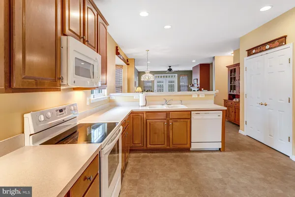 a kitchen with stainless steel appliances granite countertop a sink a stove and a refrigerator