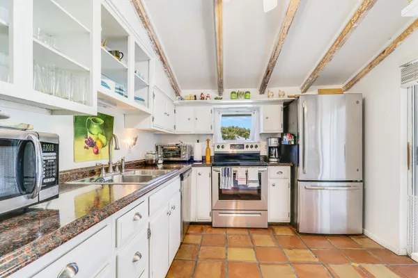 a kitchen with stainless steel appliances granite countertop a refrigerator a sink dishwasher a stove with wooden cabinets