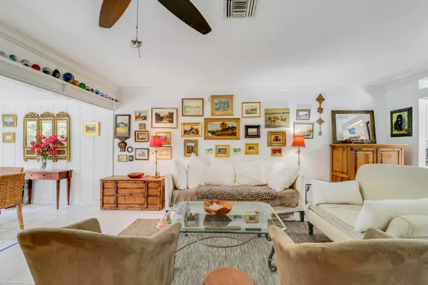 a living room with furniture kitchen view and a wooden floor