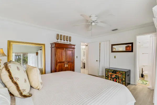 a bedroom with a bed and dresser with mirror