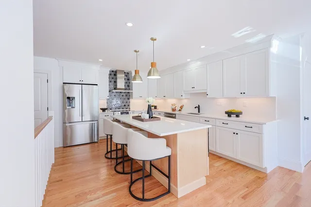 a kitchen with white cabinets and stainless steel appliances