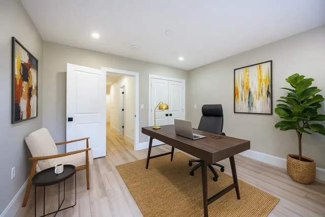 a living room with furniture a window and a potted plant