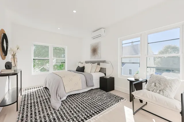 a spacious bedroom with a bed and glass door