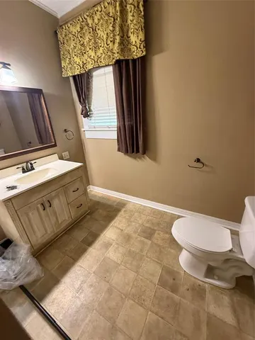 a bathroom with a toilet a sink and mirror