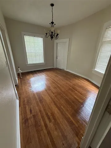 a view of a room with wooden floors and chandelier