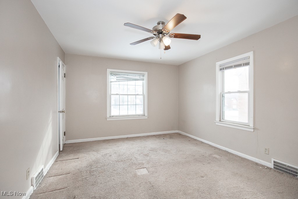 13545 Cedar Road Cleveland, OH 44118 - Photo 24 of 41 Spare room with light colored carpet, visible vents, and a healthy amount of sunlight