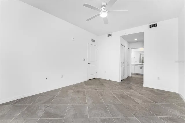 an empty room with a ceiling fan and a bathroom