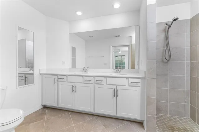 a spacious bathroom with a shower sink and mirror