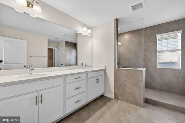 a bathroom with a double vanity sink a toilet and a shower