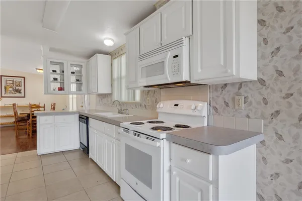 a kitchen with granite countertop white cabinets and refrigerator