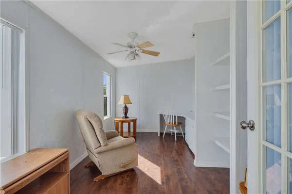 a view of a workspace with furniture and wooden floor