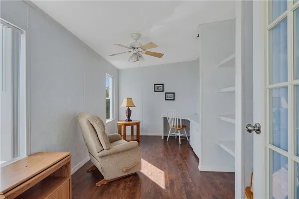 a view of a workspace with furniture and a fan