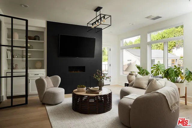 a living room with furniture fireplace and a large window