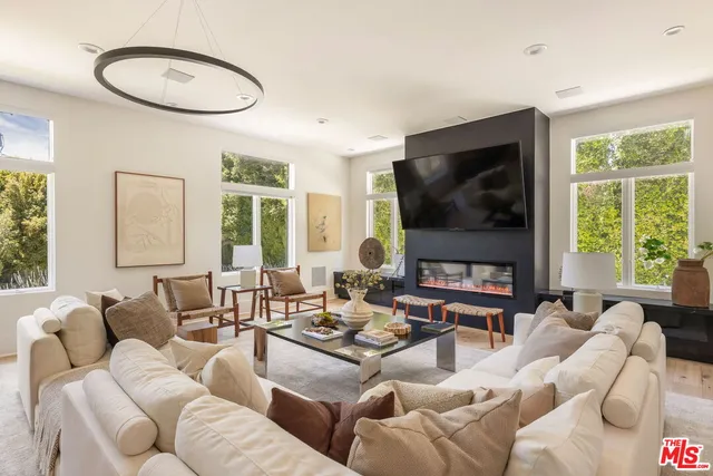 a living room with furniture a large window and a flat screen tv