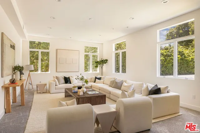 a living room with furniture and large windows