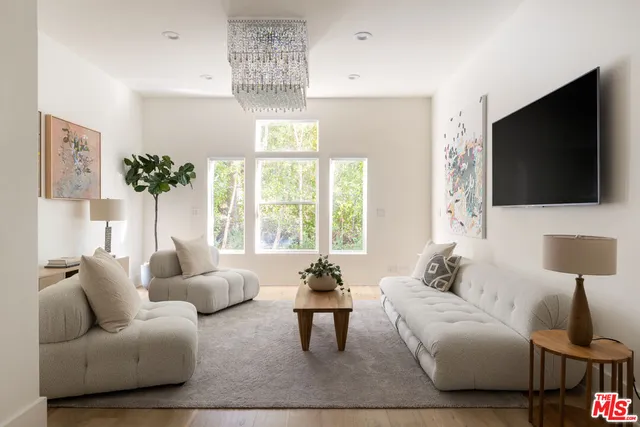 a living room with furniture a flat screen tv and a large window