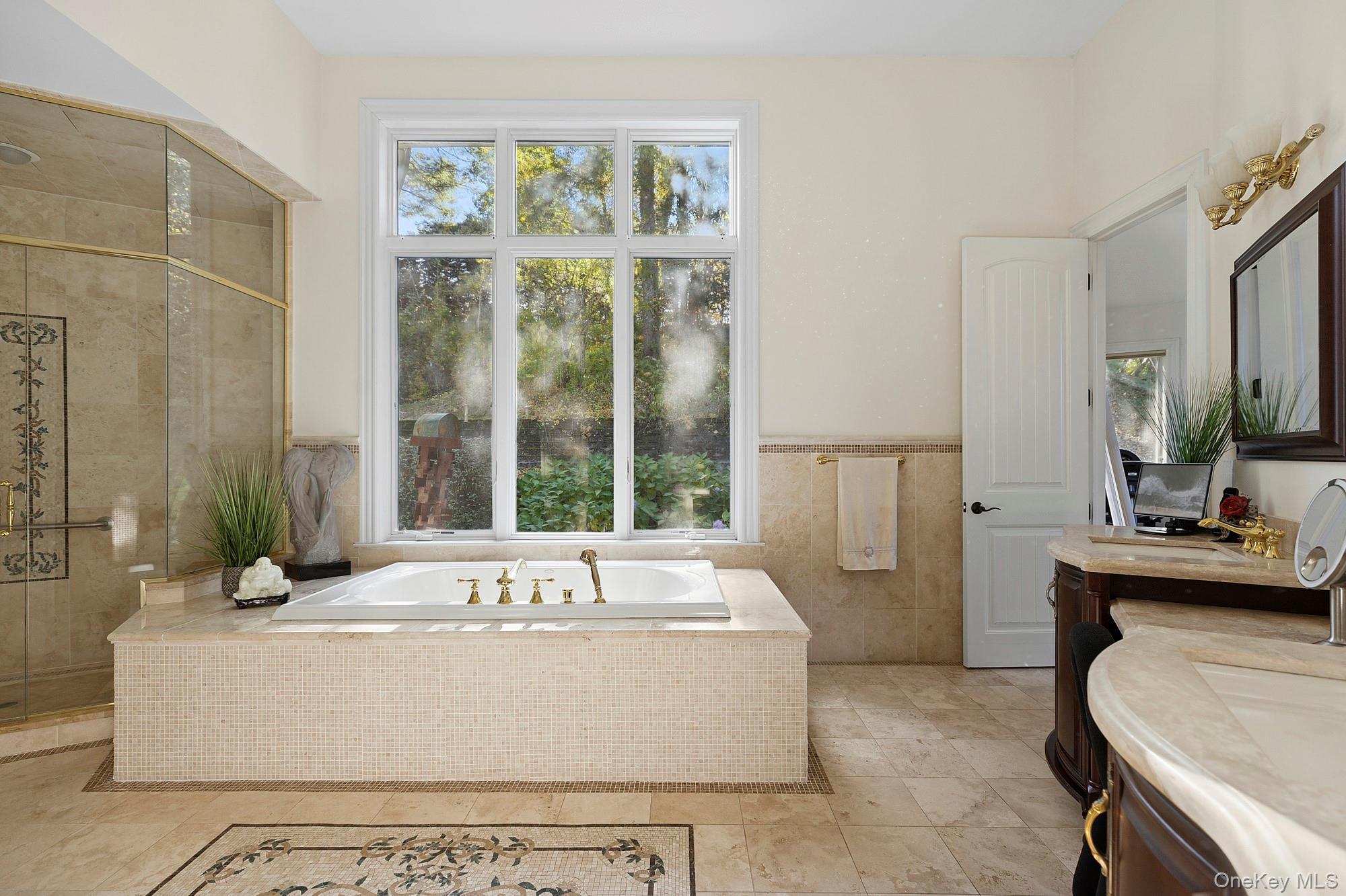 144 Round Swamp Road West Hills, NY 11743 - Photo 24 of 39 Bathroom featuring a garden tub, vanity, tile walls, a shower stall, and a wainscoted wall