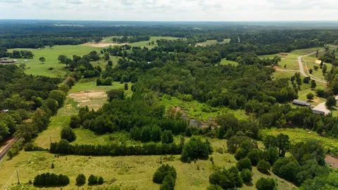 an aerial view of residential houses with outdoor space and trees