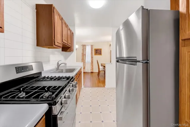 a kitchen with stainless steel appliances granite countertop a refrigerator and a stove