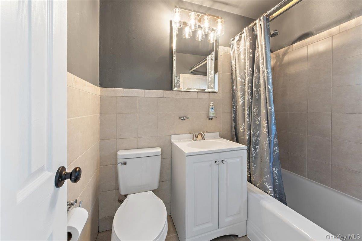 470 Tuckahoe Road, Unit 4B Yonkers, NY 10710 - Photo 11 of 17 Bathroom featuring shower / bath combination with curtain, vanity, and tile walls