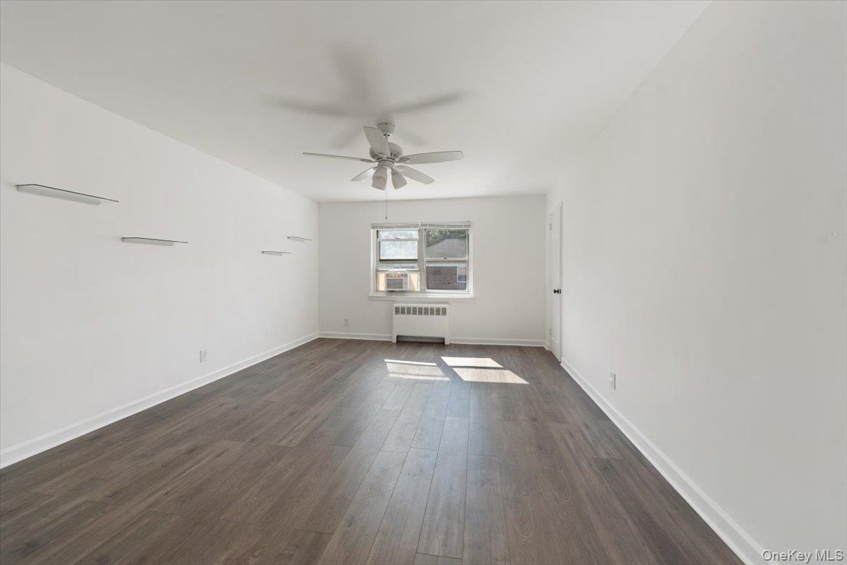 470 Tuckahoe Road, Unit 4B Yonkers, NY 10710 - Photo 4 of 17 Unfurnished living room with dark wood finished floors, radiator heating unit, and a ceiling fan