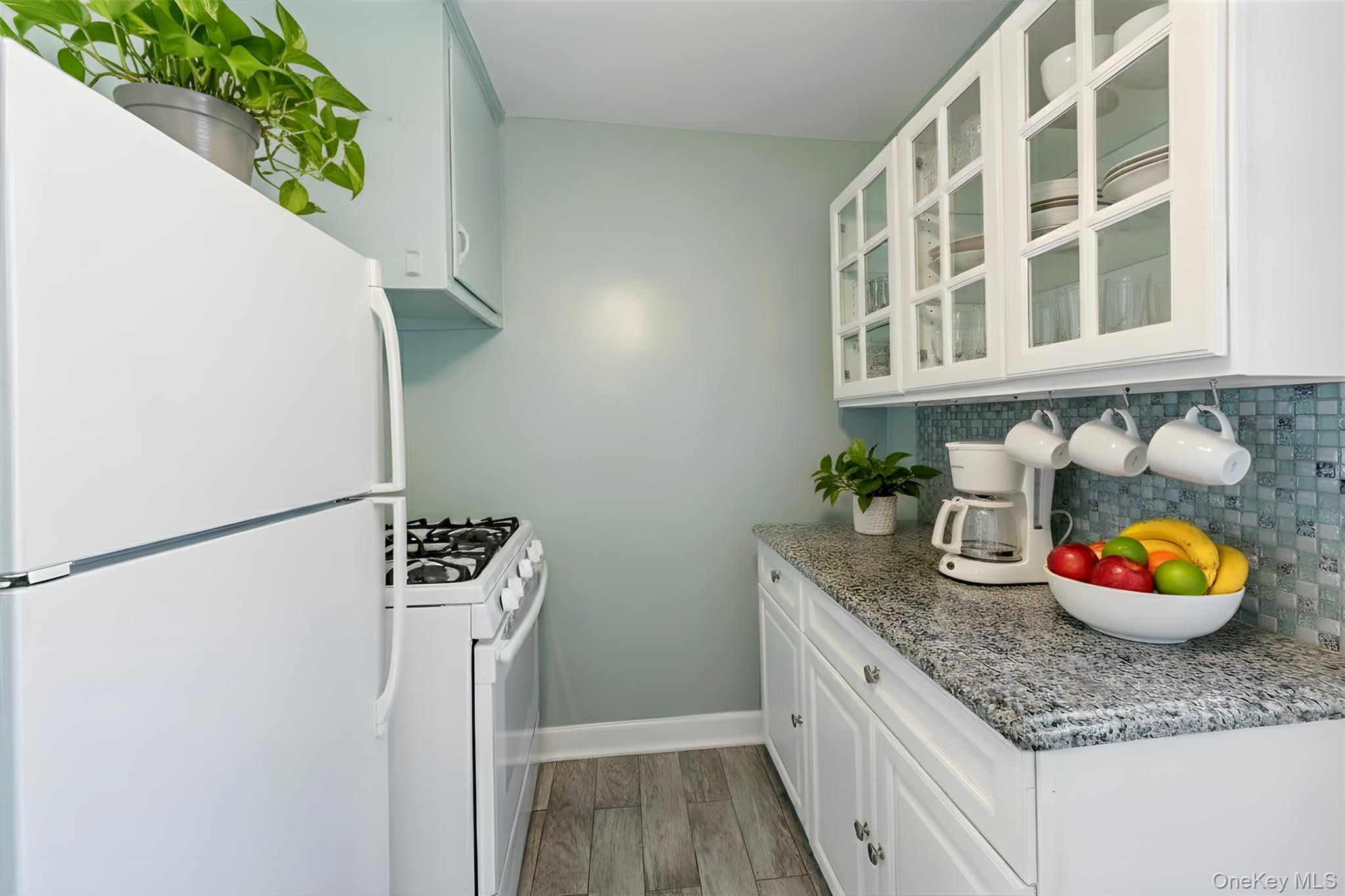 470 Tuckahoe Road, Unit 4B Yonkers, NY 10710 - Photo 8 of 17 Kitchen featuring white appliances, glass insert cabinets, white cabinetry, and light wood-style flooring