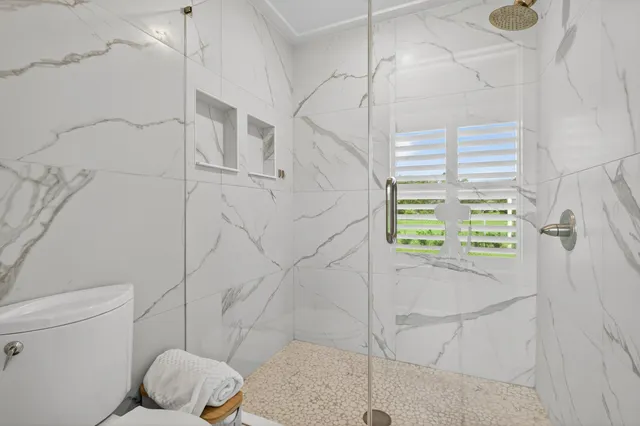 a bedroom with a bed a window and a flat screen tv