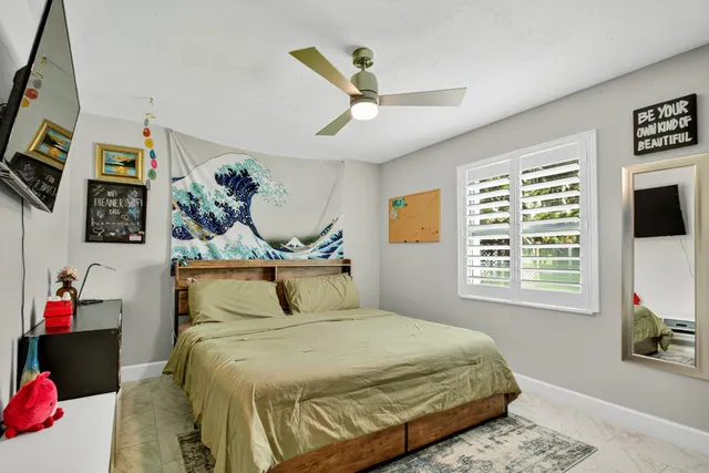 a view of a patio with table and chairs potted plants with floor to ceiling window