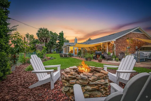 an aerial view of a house with outdoor space and a lake view in back