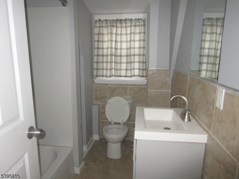 437 7th Avenue, Unit 4 Newark, NJ 07107 - Photo 5 of 7 a bathroom with a toilet sink and mirror