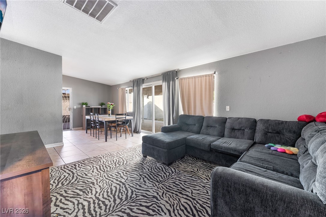 716 North 18th Street Las Vegas, NV 89101 - Photo 12 of 39 Living room featuring a textured wall, a textured ceiling, and light tile patterned floors