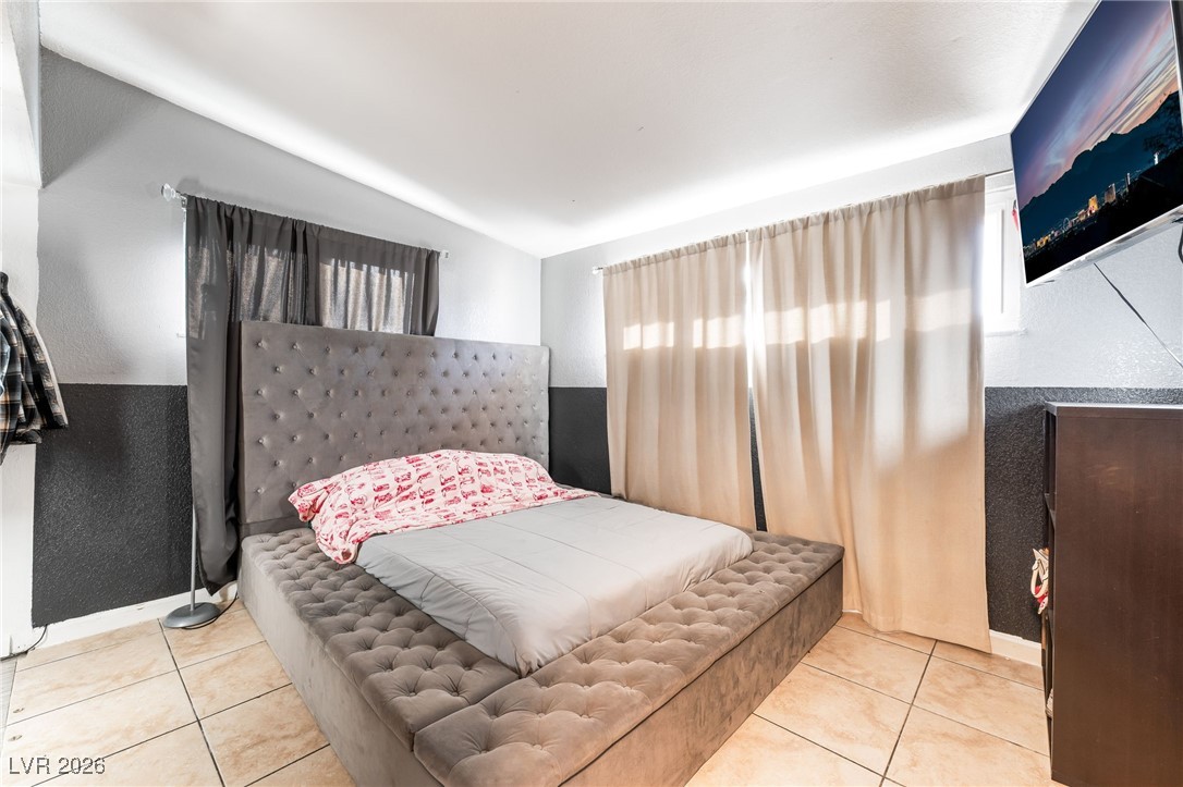 716 North 18th Street Las Vegas, NV 89101 - Photo 31 of 39 Bedroom featuring light tile patterned floors and vaulted ceiling