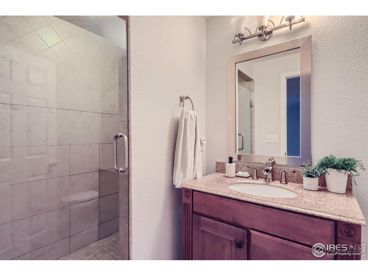 407 East Baseline Road Lafayette, CO 80026 - Photo 24 of 34 a bathroom with a granite countertop sink a mirror and shower